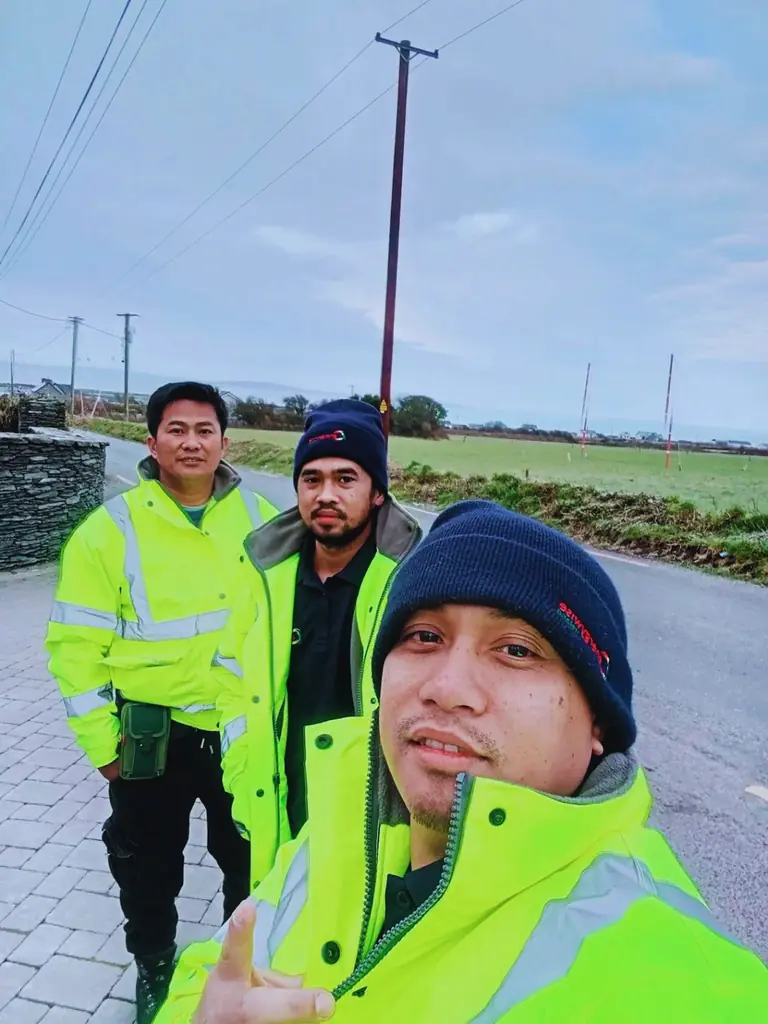 Three workers in high-visibility clothing outdoors
