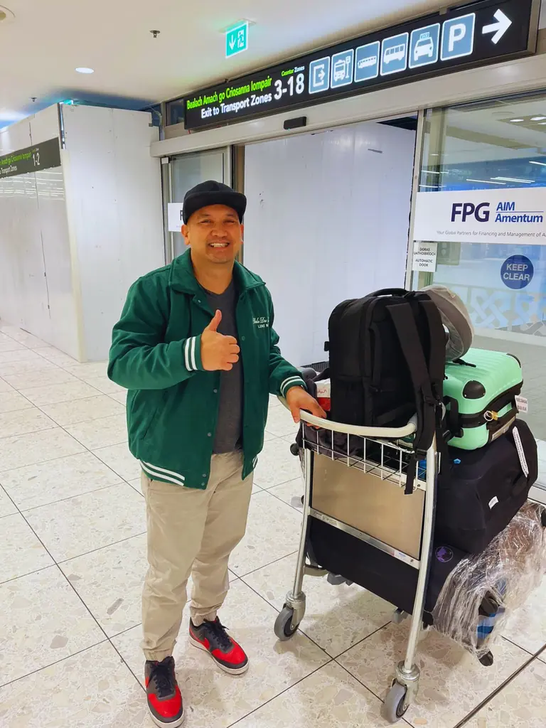 Smiling traveller with luggage at the airport