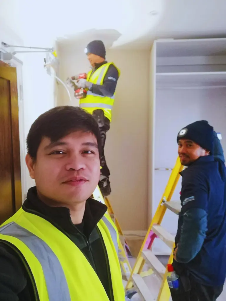 Three workers carrying out an indoor installation